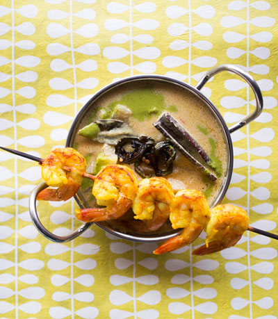 shrimp on a skewer on top of soup bowl